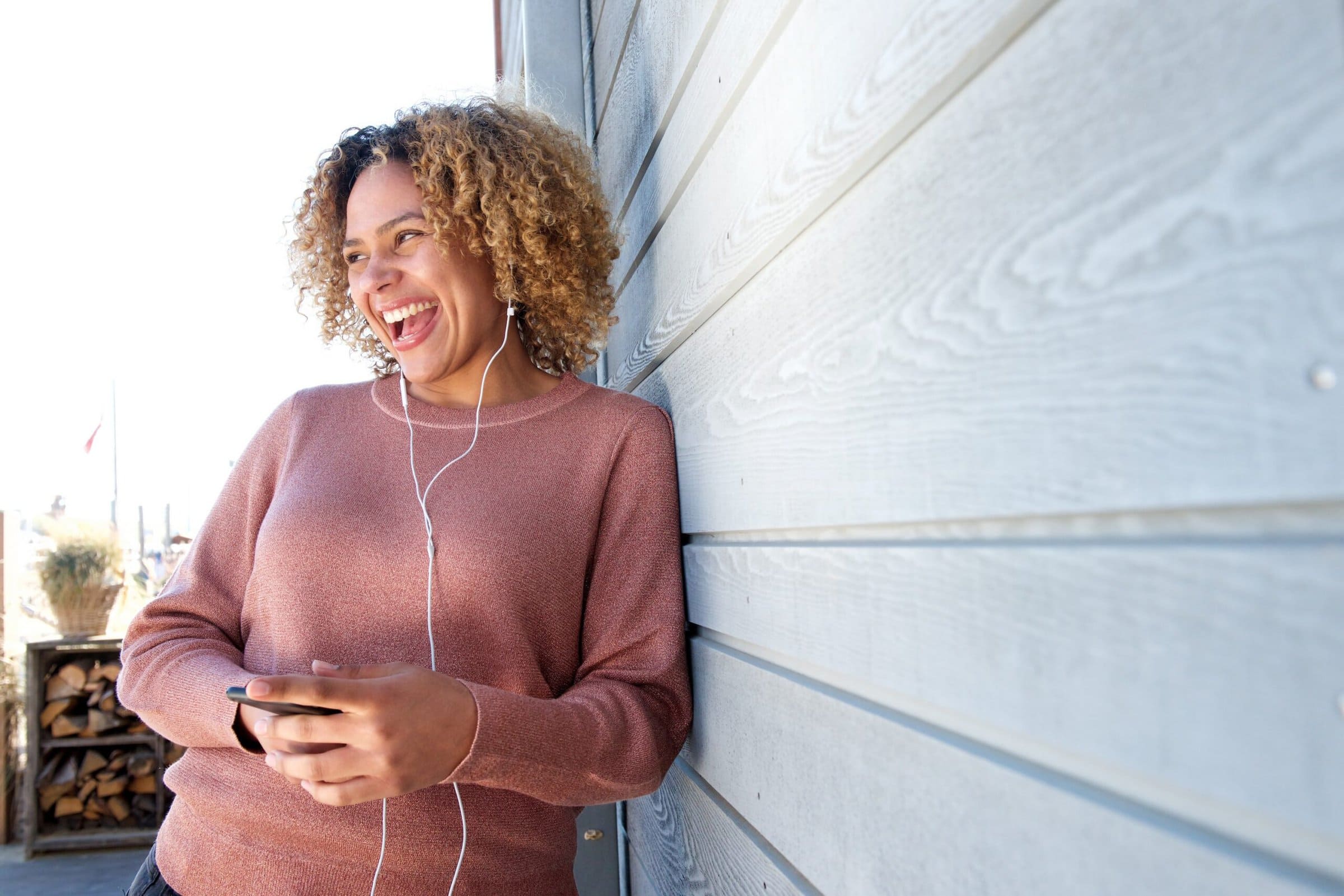 Portrait,Of,Happy,Woman,Enjoying,Music,With,Earphones,And,Mobile