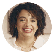Smiling woman with curly hair wearing a white top, set against a circular coral background. Represents positivity, confidence, and Noom’s diverse and supportive user community.
