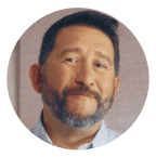 Smiling man with short dark hair and a beard, wearing a light-colored shirt, framed in a circular coral background. Represents trust, experience, and Noom’s supportive member community.